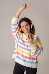 Pretty young teenager girl in headphones listening to music on m