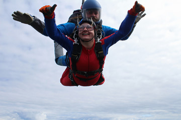 Tandem skydiving. Man and woman are in the sky.