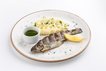 Grilled whole fish with mashed potato, lemon and soy sauce isolated on white background