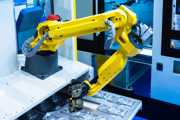 Robot manipulator arm. Manipulator puts the workpieces in the machine for processing. Robotic technology. Automation of production. Process of work of the robot manipulator. Robots in production.