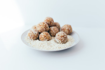 Fruit balls in a nut crumb on a white plate