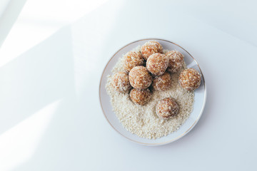 Fruit balls in a nut crumb on a white plate