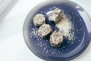 Round chocolate cakes in a nut crumb on a purple plate