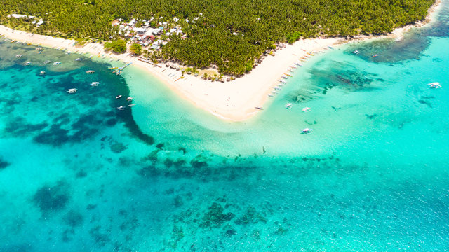 Coastline of a tropical island with a white beach and turquoise lagoon. Daco island, Philippines. White sandy beach, top view.