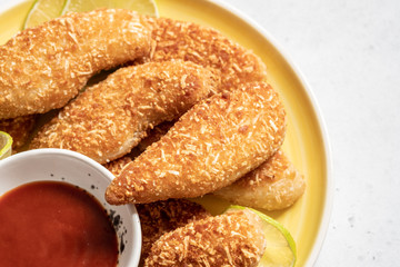 Chicken strips nuggets with tomato sauce on a plate