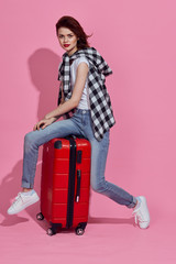 young woman sitting on suitcase