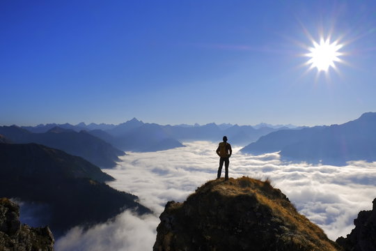 Mann, Person auf Berggipfel mit Aussicht auf Gebirge in den Alpen