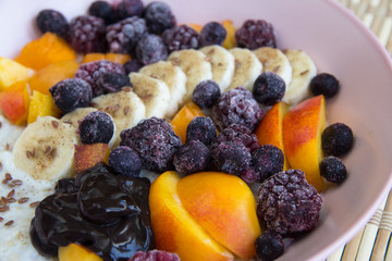 Oatmeal with bananas, apricots, blueberries, blackberries, chocolate paste and sesame seeds