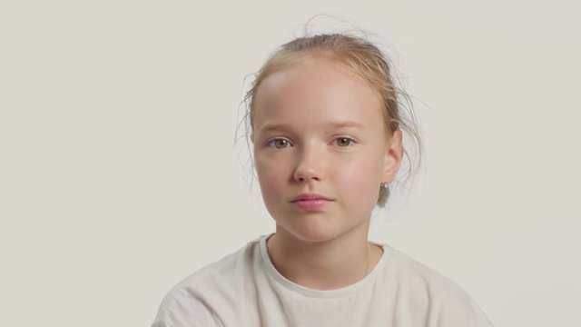 young girl makes facepalm alone in studio on white