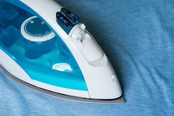 Electric iron and shirt on ironing board.