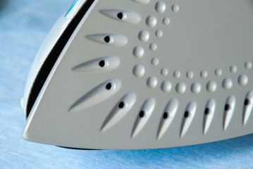 Electric iron and shirt on ironing board.