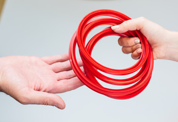 Oil seal for engines Industrial use. Hand holding pink elastic rubber band on white background....