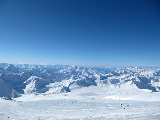 Snowy Greater Caucasus ridge with the Mt. Ushba at winter sunny day. View from Pastuchova kliffs at Elbrus ski slope, Kabardino-Balkaria, Russia