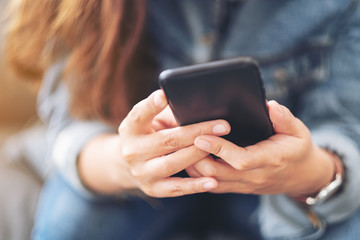 Closeup image of a beautiful asian woman holding , using and looking at smart phone
