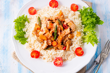 Turkey fricassee on rice with asparagus and paprika