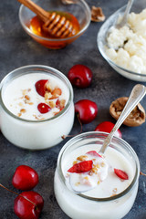 Fermented yogurt kefir in small bottles with cherries and walnuts