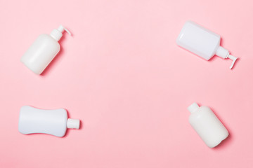 Set of White Cosmetic containers isolated on pink background, top view with copy space. Group of plastic bodycare bottle containers with empty space for you design