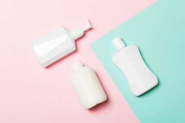 Set of White Cosmetic containers isolated on yellow background, top view with copy space. Group of plastic bodycare bottle containers with empty space for you design