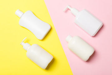 Set of White Cosmetic containers isolated on yellow background, top view with copy space. Group of plastic bodycare bottle containers with empty space for you design