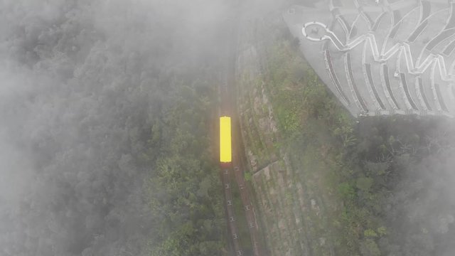 Yellow funicular in the mountains forest through the clouds aerial video in Vietnam Ba Na Hills amusement park