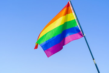 LGBT waving flag in the sky on flagpole