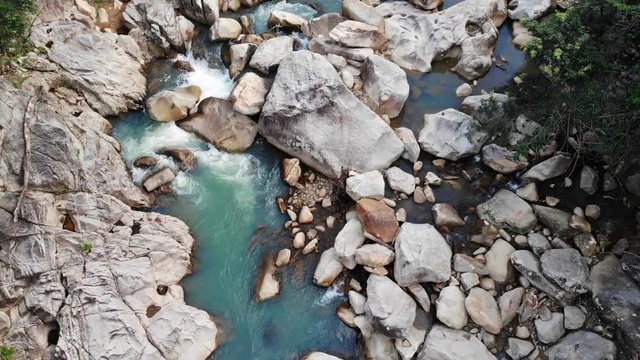 Rocky River with Cascades and Clean Water in a Tropical Forest. Smooth Camera Lift. Aerial View