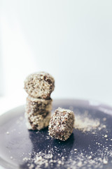 Round chocolate cakes in a nut crumb on a purple plate with a blurred background