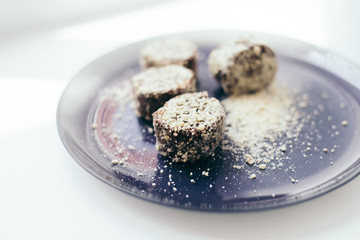 Round chocolate cakes in a nut crumb on a purple plate with a blurred background