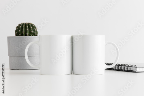 Download Two Mugs Mockup With A Notebook And A Cactus In A Pot On White Table Wall Mural Snoflinga