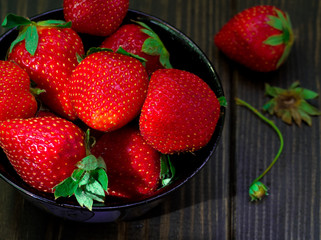 strawberries in a bowl against a dark background