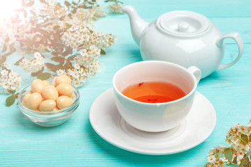 Green tea in a ceramic cup with branches of blossoming tree branches