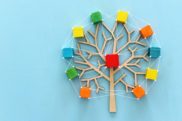 Business image of wooden tree with colorful cubes over blue table, human resources and management...