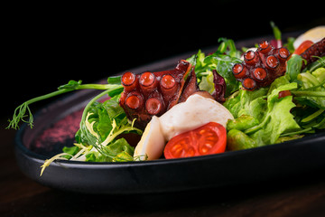 seafood salad, octopus, scallops on a dark background