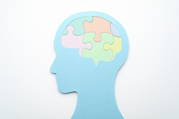 Brain and mental health care concept. Mental management. Head silhouette and brain shaped puzzle pieces on white background.