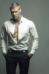 Male fashion, beauty concept. Portrait of brutal young man with short wet blond hair wearing white...