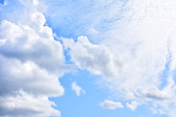Beautiful blue sky with cumulus, selective focus. Blue sky background with fluffy white clouds and sunlight on backdrop. Idyllic wallpaper with cloudy sky and space for text. Cloudscape 