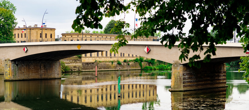 Panorama. Building with reflection in water, bridge over river Moselle. Thionville, France