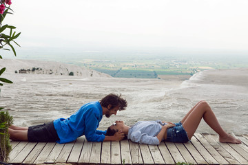couple man and woman sit back on a wooden floor in the street in Pamukkale - Powered by Adobe