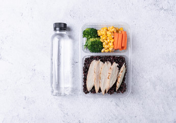Fresh healthy diet lunch box with vegetable salad and water bottle on table background.