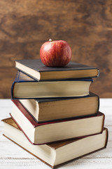 Apple on top of a pile of books front view
