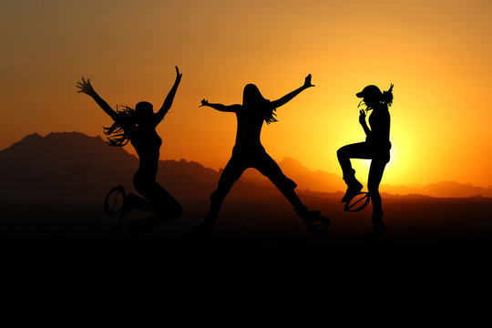 Junge Frauen beim Kangoojump vor einem Sonnenuntergang