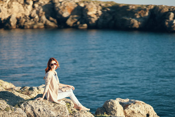 Fototapeta na wymiar woman sitting on a rock near the sea