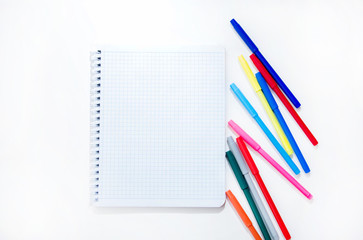 Colored markers and a notebook on a white background. The concept of creativity and education. Back to school. Layout. Flat bed. The view from the top. Copy space. Summertime.