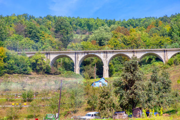 Fototapeta na wymiar bridge with arches near rural settlement 