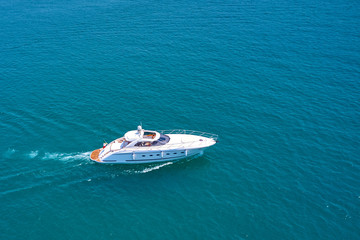 The yacht is white at high speed moving against the background of turquoise waters. Side view. Aerial photography with drone. 