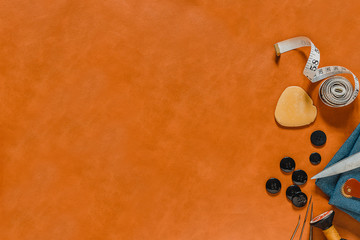 Crafting tools on natural leather on background. Frame with sewing tools and accessories. Top view.