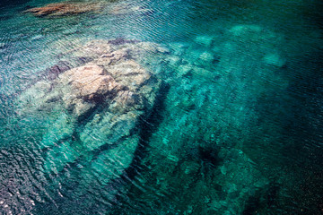 Türkises Wasser mit Fels in einem See