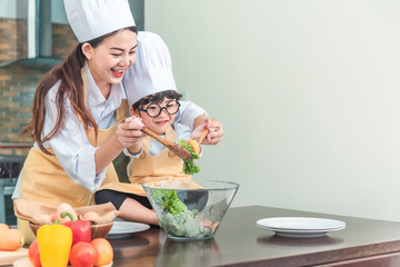 Happy family in the kitchen. mother and child daughter preparing the dough, salad