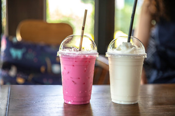 Iced white milk and Pink strawberry milk shake for summer  on wood table background.