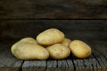 Fresh potatoes on an old wooden table